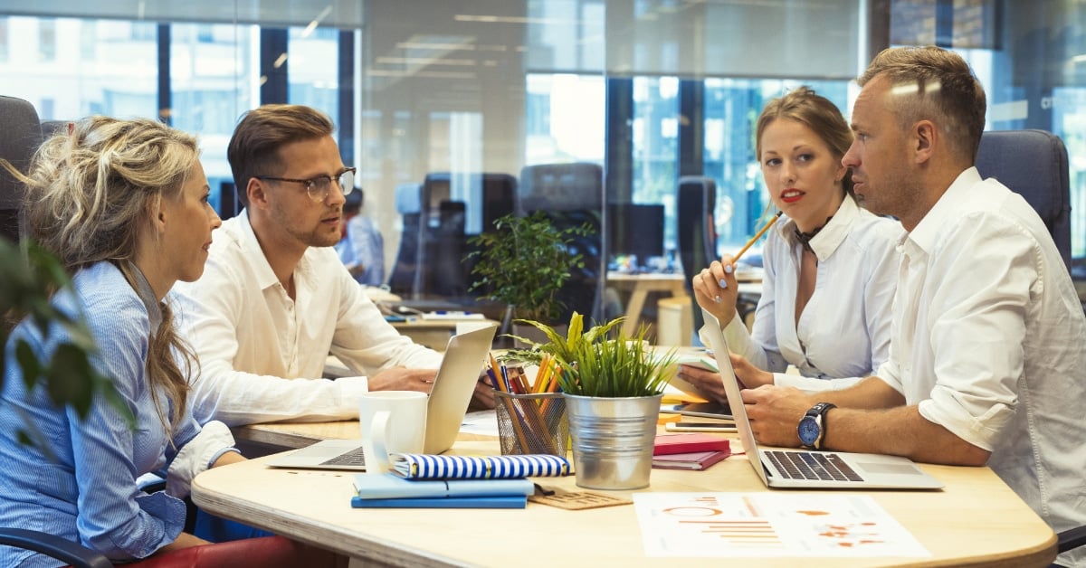 Four coworkers sitting around a table.